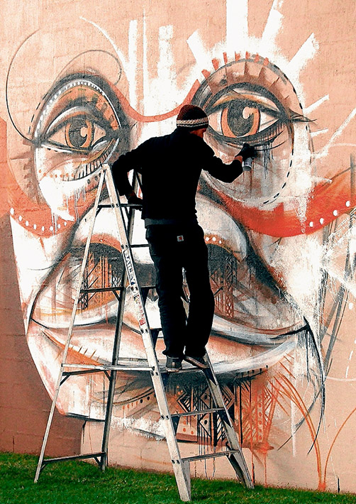 Off the wall: Michael Husser working on Humans, one of two murals he has created as part of his artist in residence at Police Point Shire Park.