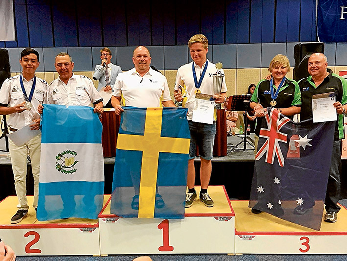 Podium place: Daniel Arapakis with dad Andrew, alongside other model aeroplane competitors from Sweden and Guatemala.