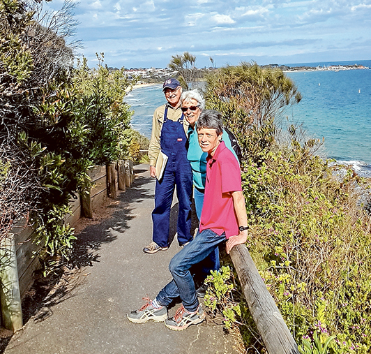 Track fans: Peter Nicholson, left, Barbara Johnston and Kate Philip of the Caraar Creek Coastal Cliff Pathway steering committee on the “goat track” overlooking Mills Beach (left) and Mornington harbour. They want the shire and state government to repair the iconic, 100-year-old track. Picture supplied