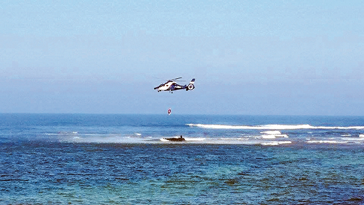 Timely pick up: Two teenagers are plucked to safety by the police Air Wing Sunday afternoon from Mushroom Reef, Flinders. Picture: Matt Drysdale