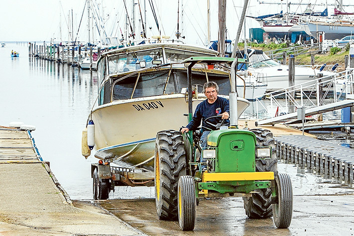 Fishing trip gone wrong: Rescuer Howard Fisher’s cabin cruiser is brought ashore at Yaringa harbour, Sunday morning. Picture: Gary Sissons