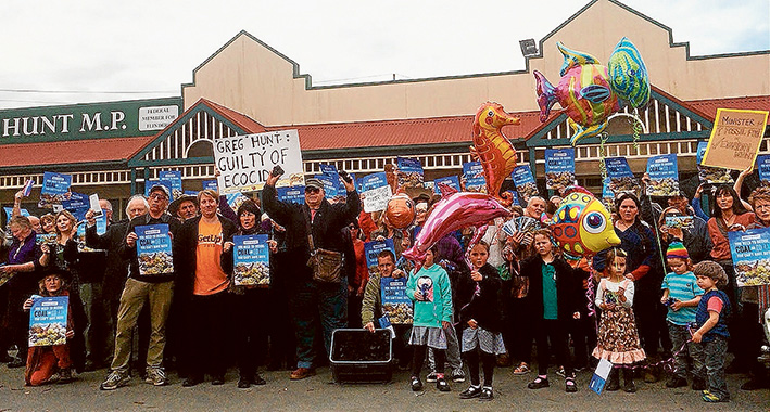 Coal protest: Men, women and children outside the office of Flinders MP to protest at the mining of coal and its export from a port within Queensland’s Great Barrier Reef. Simon Hawking, kneeling centre, helped carry a crate of coal into the office. Picture: Supplied