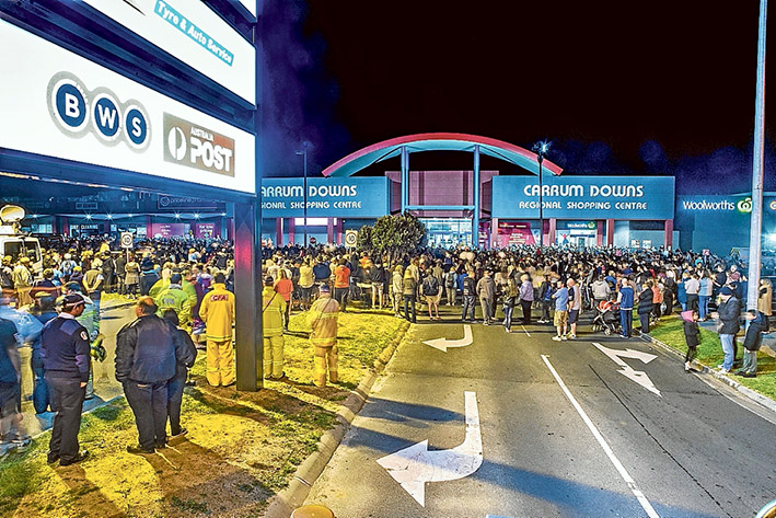 Tributes after tragedy: The community rallied round to show support for the Lehane family in the wake of Andrea Lehane’s death by laying flowers, below right, and attending a vigil, above, at Carrum Downs Regional Shopping Centre. Pictures: Gary Sissons