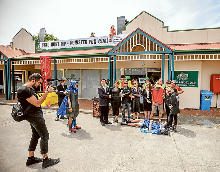 For the record: Protesters on the roof, street theatre below. Protest activities outside the Hastings office of Environment Ministrer Greg Hunt are all recorded and quickly packaged to be spread on social media.