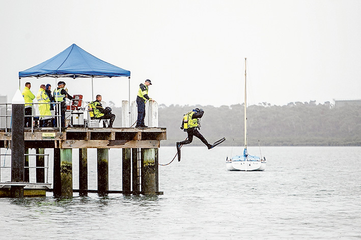 Bay search: A police diver jumps into the water to search for the missing man whose empty wheelchair was left on Hastings pier. Picture: Yanni