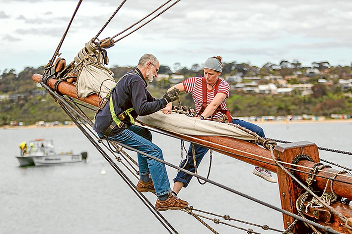 Crew members Eden and Konrad secure the foersail or spiniker before departure.