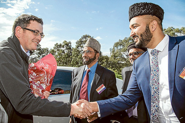 Peaceful meeting: The Premier Daniel Andrews is greeted by Imam Wadood Janud, right, on his arrival at a peace symposium at the Bait-ul-Salam mosque in Langwarrin. Ahmadiyya Muslim Community Australia national president Imam Inam-ul-Haq Kauser is in the centre. Top left, children of mosque members singing the national anthem. Pictures: Gary Sissons
