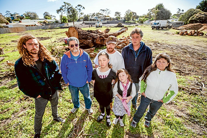Jason Legg, Mal Campbell, Craig Thomson, Mal Legg, Dorris Campbell and Rose and kids Eve Thomson, left, with the remains of the aged eucalypt. Main picture: Yanni